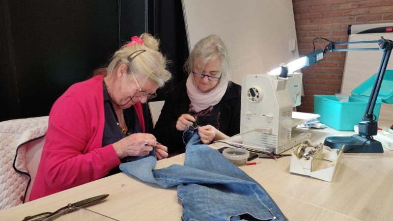 dames herstellen een broek in het Repair Café van Oudenaarde